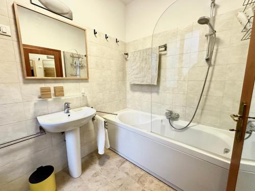 une salle de bains avec lavabo, baignoire et miroir dans l'établissement Cà De Sbiess, à Venise