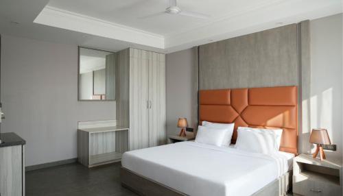 a bedroom with a large white bed and a mirror at The Porto by Lagom, Anjuna, Vagator beach in Vagator