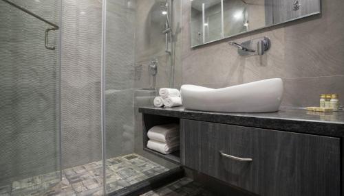 uma casa de banho com um lavatório e uma cabina de duche em vidro. em The Porto by lagom , Anjuna, vagator beach em Vagator