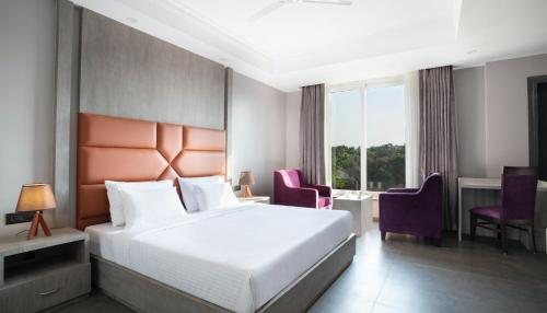 a hotel room with a bed and a table and chairs at The Porto by Lagom, Anjuna, Vagator beach in Vagator
