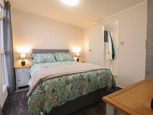 a bedroom with a bed and two lamps and a table at Holmside in Market Drayton