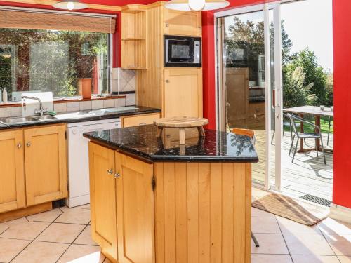 a kitchen with wooden cabinets and a black counter top at Seafield in Ballymoney Cross Roads