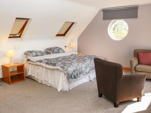 a bedroom with a bed and a chair at Seafield in Ballymoney Cross Roads