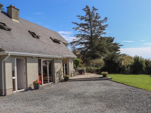 a house with a gravel driveway next to a yard at Seafield in Ballymoney Cross Roads