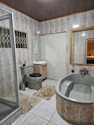 uma casa de banho com uma banheira grande e um WC. em Vintage@1420 em Ngodini