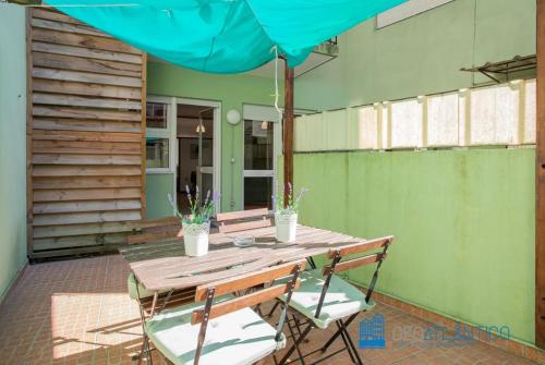 einen Holztisch mit zwei Stühlen und einem Sonnenschirm in der Unterkunft Porto Sé Classic Terrace Apartment in Porto