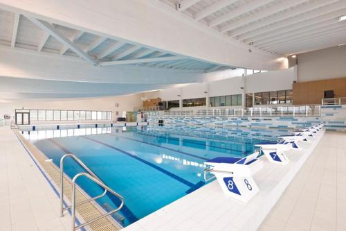 una gran piscina con sillas en una habitación grande en Comfortable house G00gle-SHAPE- Chièvres Air Base en Saint-Ghislain