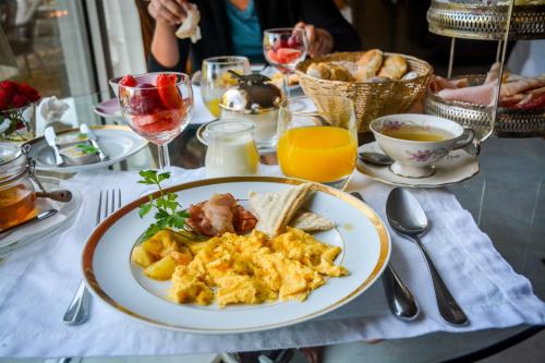 Una mesa con un plato de huevos revueltos y tostadas en Carmo's Boutique Hotel - Small Luxury Hotels of the World, en Ponte de Lima