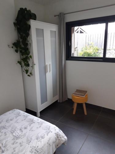 a bedroom with a bed and a window and a stool at Superbe Maison en baie du Mont St Michel in Vains