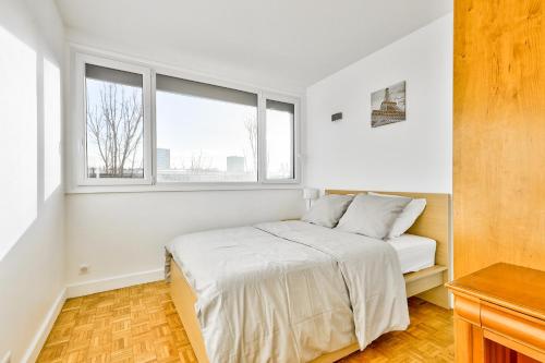 a white bedroom with a bed and two windows at Appartement lumineux et cosy à 15min de Paris in Antony