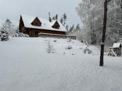 a house covered in snow in front at Leśny Dworek Podjazy in Podjazy