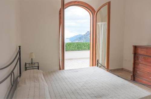 ein Schlafzimmer mit einem Bett und einem großen Fenster in der Unterkunft Casa Vacanze Agape in Positano