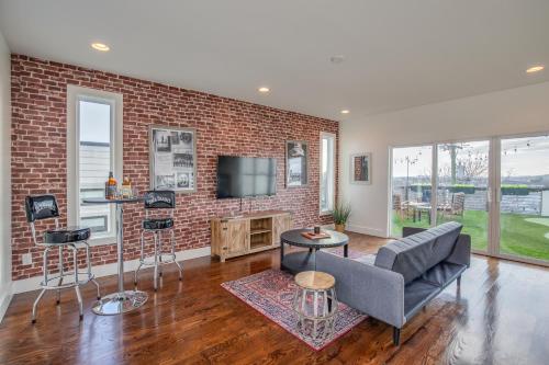 a living room with a couch and a brick wall at Jack Daniels House with Rooftop Golf, City views! 8min to Whiskey Row! Sleeps 10! in Nashville