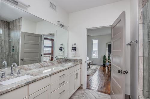 un bagno con due lavandini e un grande specchio di Whiskey House with Rooftop Golf, City views! 8min to Downtown! Sleeps 9! a Nashville
