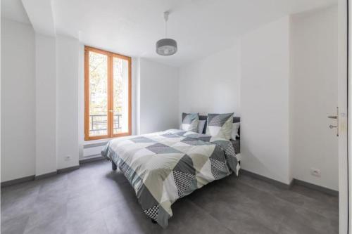 a bedroom with a bed and a window at Appartement Montparnasse in Paris
