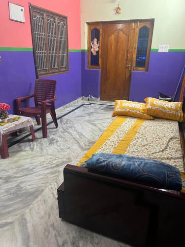 um quarto com uma cama, uma mesa e uma cadeira em SM Homestays 2 em Tirupati