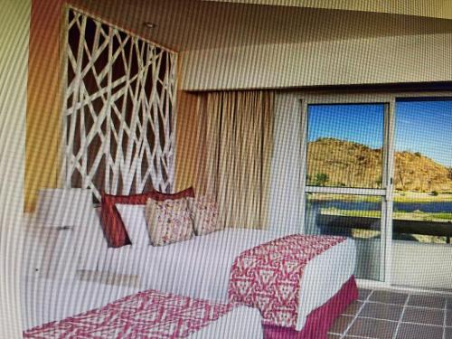 - une chambre avec un lit et une grande fenêtre dans l'établissement HOTEL LORETO BAY, à Loreto