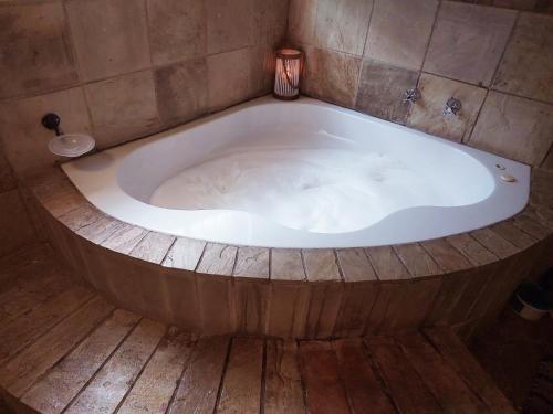 a bath tub in a room with a wooden floor at Adorable Designs in Pretoria