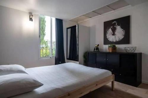 sypialnia z dużym łóżkiem i oknem w obiekcie Appartement avec mezzanine w Nicei