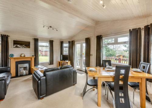 a dining room with a table and chairs and a fireplace at Ruby Country Lodges in Beaworthy