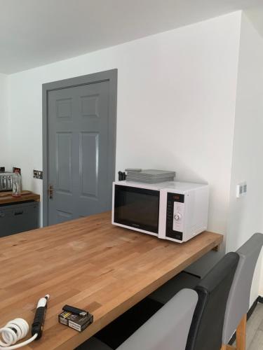 a microwave sitting on top of a wooden table at Erehwon - History in Bodmin in Bodmin