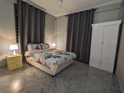 um quarto com uma cama e dois candeeiros numa mesa de cabeceira em Suji House em Dodoma