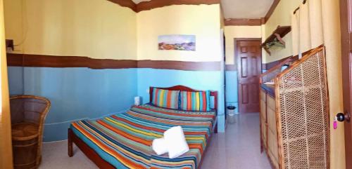 ein Schlafzimmer mit einem Bett in einem Zimmer in der Unterkunft ALFA Beach Front Lodge in El Nido