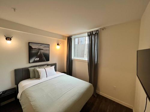 sypialnia z dużym łóżkiem i oknem w obiekcie Dt 1 Br 1bath Cozy Suite 8 Min Walk To Arena w mieście Edmonton