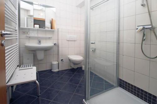 a bathroom with a toilet and a sink and a shower at Yachthafenresidenz-Wohnung-9108-882 in Kühlungsborn
