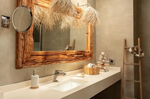 een badkamer met een wastafel en een spiegel bij Somnis in La Mola