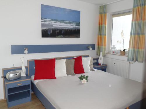 キュールングスボルンにあるYachthafenresidenz-Wohnung-8203-851のベッドルーム1室(赤と白の枕が備わるベッド1台付)