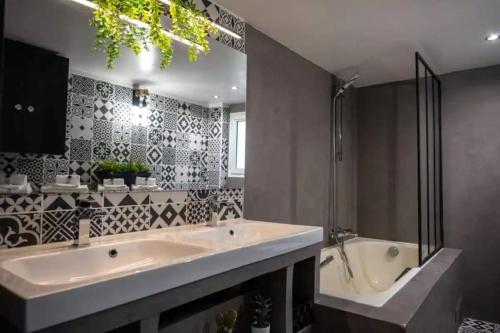 een badkamer met een grote wastafel en een bad bij Appartement avec mezzanine in Nice