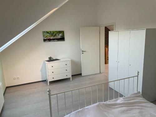 a bedroom with a bed and a dresser and a staircase at Citywohnung Würselen in Würselen