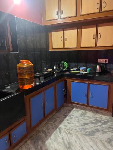 a kitchen with black counter tops and blue cabinets at SM Homestays 2 in Tirupati