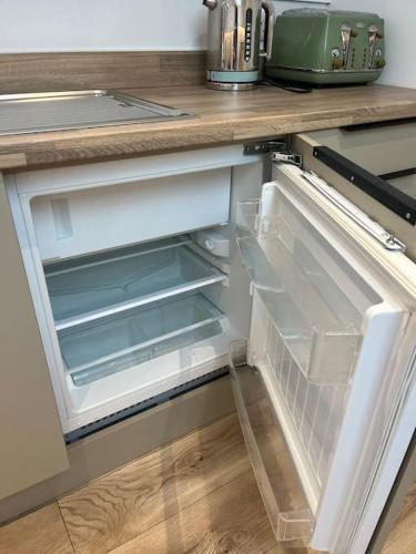 an empty refrigerator with its door open in a kitchen at Garage loft conversion Killinchy in Killinchy
