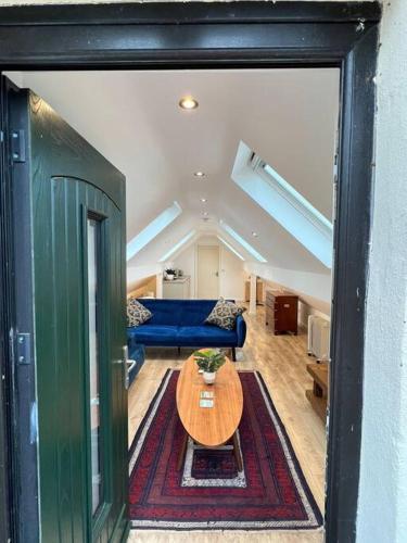 a living room with a table and a blue couch at Garage loft conversion Killinchy in Killinchy