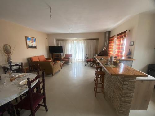 a living room with a kitchen and a living room with a bar at Rodopi Apartment in Skala Kefalonias