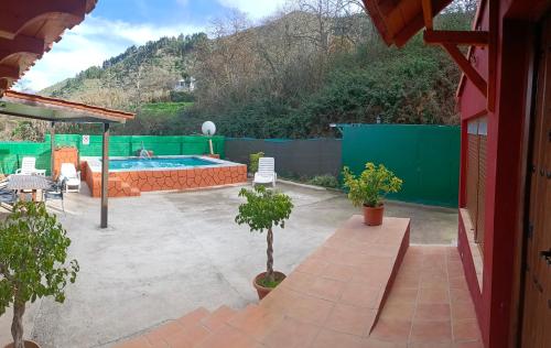 ベガ・デ・サン・マテオにあるChalet Ruta Las Lagunetasのプールと木々のあるパティオ、フェンス