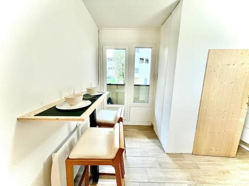 a kitchen with a counter and a table and chairs at Spacieux T2 avec extérieur in Marignier