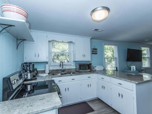 a kitchen with blue walls and white cabinets at Changes In Latitudes in Folly Beach