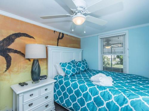 a blue bedroom with a bed and a ceiling fan at Changes In Latitudes in Folly Beach