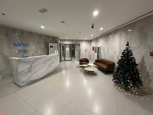 a christmas tree in a lobby with a couch at Modern 1BR in Dubai South Mag5 with all utilities in Dubai