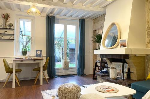 ein Wohnzimmer mit einem Schreibtisch und einem Kamin in der Unterkunft Le Jardin - Pl St Sauveur - Hypercentre in Caen