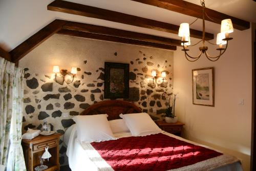 a bedroom with a large bed with a red blanket at L'ESCALE DE CAMILLE in Murat
