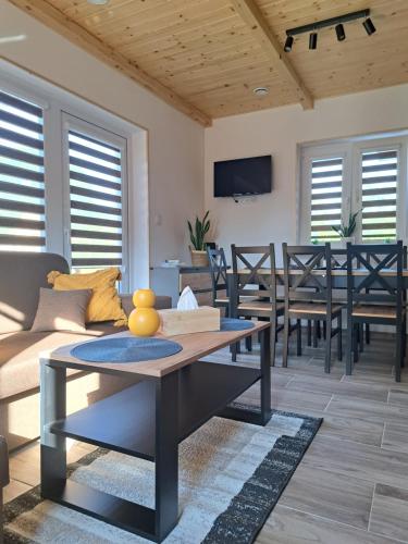 a living room with a couch and a table at Całoroczne Domki Wypoczynkowe - Osada pod Górą in Ustrzyki Dolne