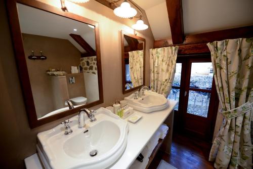 La salle de bains est pourvue de 2 lavabos et d'un grand miroir. dans l'établissement L'ESCALE DE CAMILLE, à Murat