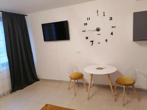 Zimmer mit einem Tisch und einer Uhr an der Wand in der Unterkunft Studio proche du centre-ville in Carcassonne