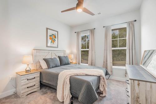 - une chambre avec un lit et un ventilateur de plafond dans l'établissement Stylish Barefoot Townhome, Sleeps 10 NEW!, à Myrtle Beach