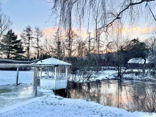 a gazebo in the snow next to a river at Cozy Rooms at Organic Vinery, Vesterhave Vingaard - see more at BY-BJERG COM in Karrebæksminde