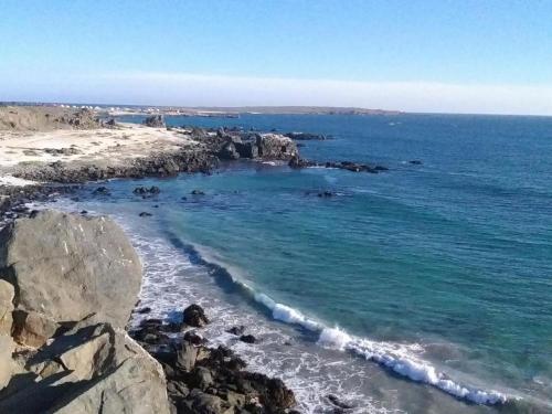 a view of a beach with rocks and the ocean at Refugio del Archipielago in Punta de Choros